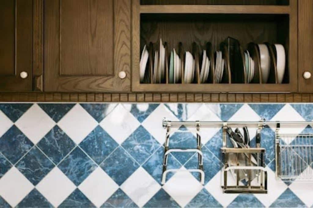 Rangement de vaisselle dans une cuisine avec crédence en carreaux bleus et blancs