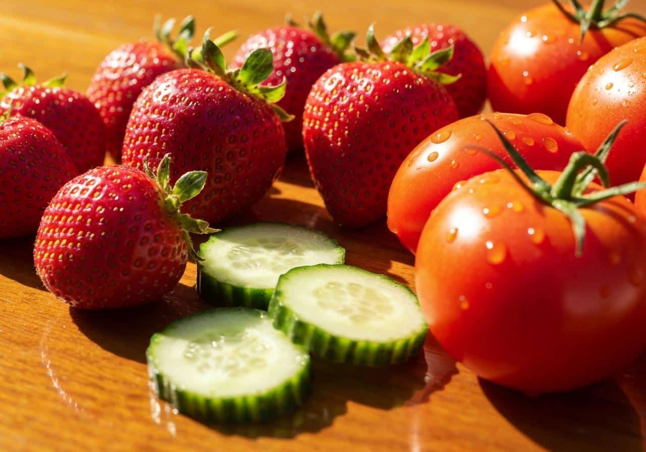 Fraises fraîches et légumes aqueux sur fond bois